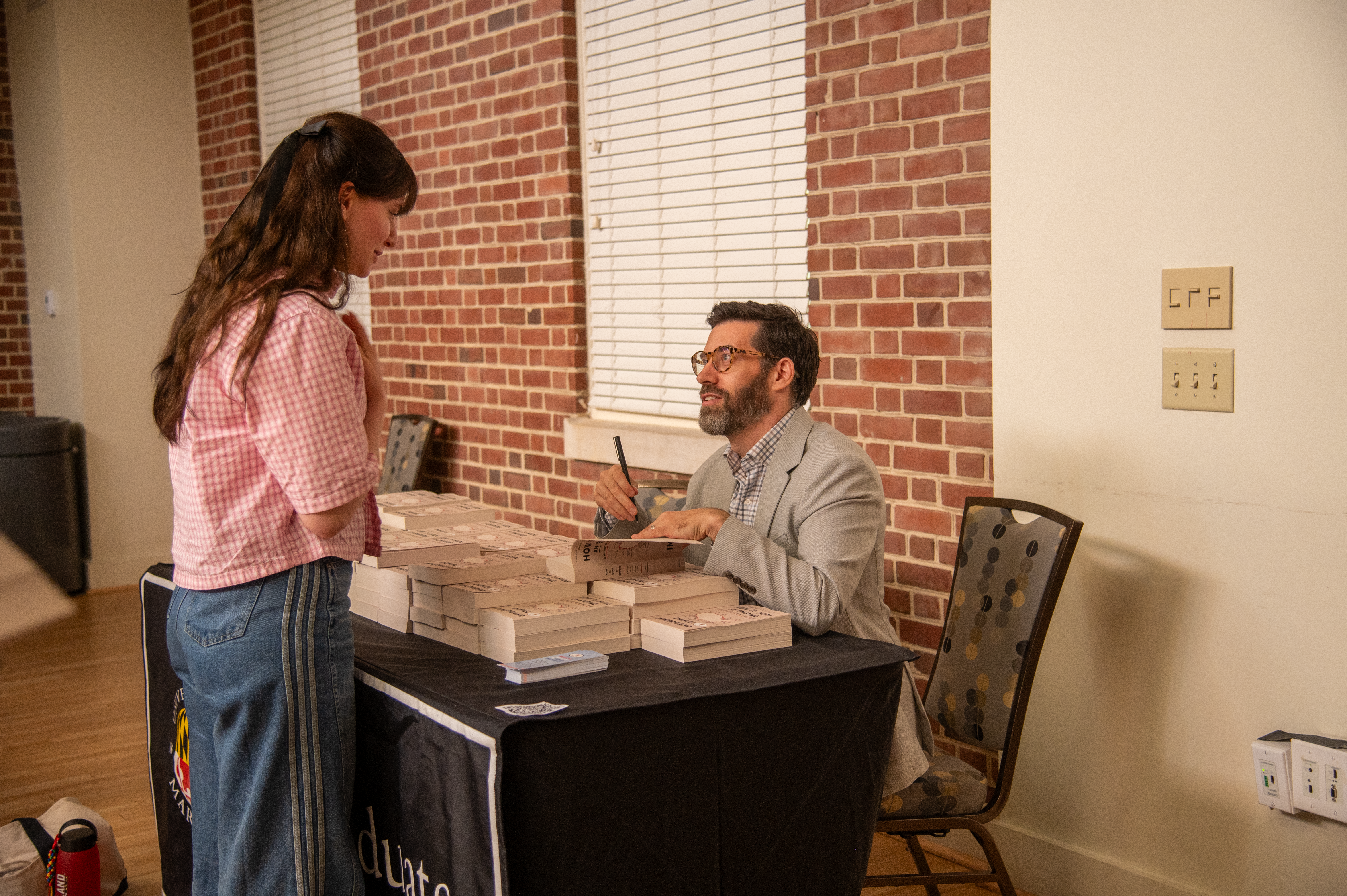 Daniel Immerwahr signs a copy of his book for a student